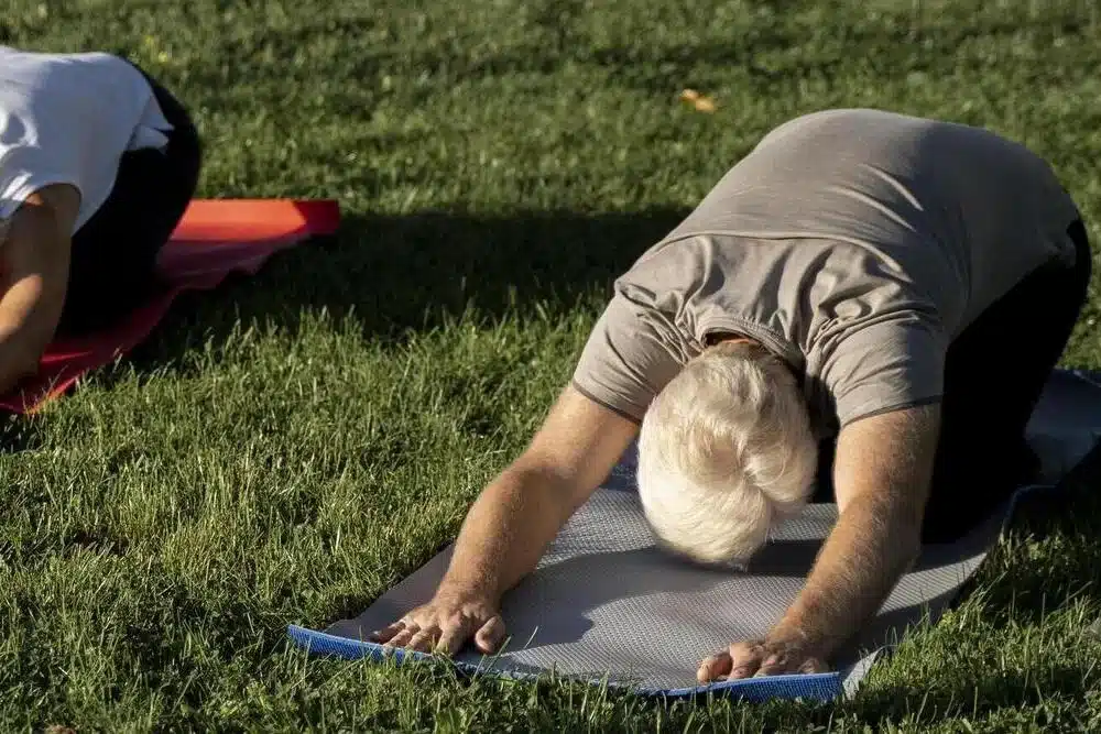 personas de angulo alto al aire libre haciendo yoga
